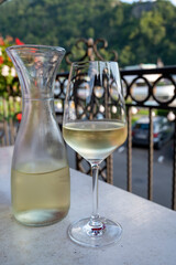 Tasting of white quality riesling wine served on outdoor terrace in Mosel wine region and old German town on background, Germany