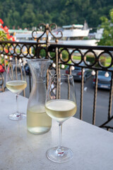 Tasting of white quality riesling wine served on outdoor terrace in Mosel wine region and old German town on background, Germany