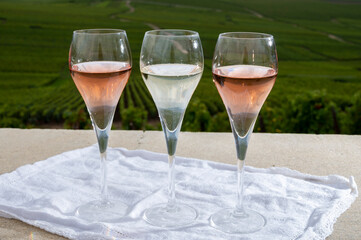 Glasses of white and rose brut champagne wine and view on grand cru vineyards of  Montagne de Reims near Verzenay, Champagne, France