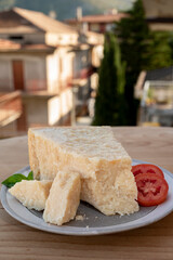 Cheese collection, piece of matured cow cheese pasmesan parmigiano reggiano and Italian houses on...