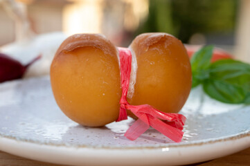 Cheese collection, yellow smoked Italian cow milk cheese scamorza with Italian houses on background