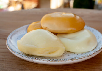 Cheese collection, variety of Italian cow milk cheese flat scamorza with Italian houses on background
