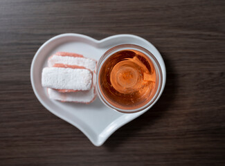 Symbols of Reims on heart shaped board - glass of rose brut champagne and rose biscuits