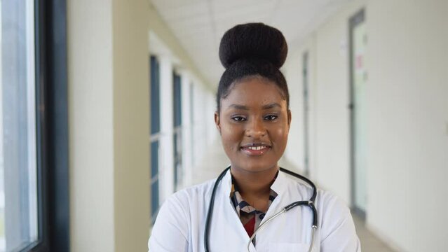 Portrait of african american female physician or intern professional general practitioner posing with stethoscope looking at camera in clinic