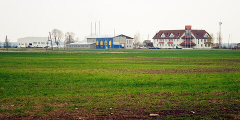 A green field for crops and a modern farm