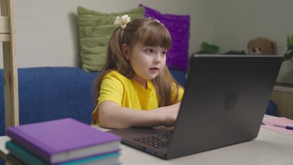 homeschooled child does lessons on laptop remotely, studying school program in computer, educational assignments for preschoolers, little kid writes text keyboard, happy childhood with game program