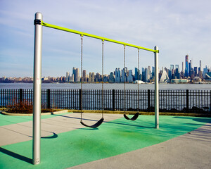 Swing set with the background of Manhattan skyline and Hudson River weehawken NJ USA