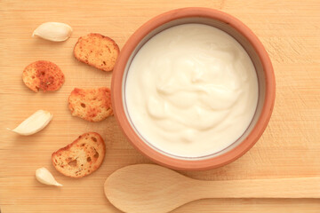 Fototapeta na wymiar Sour cream in a wooden bowl. Farm organic product