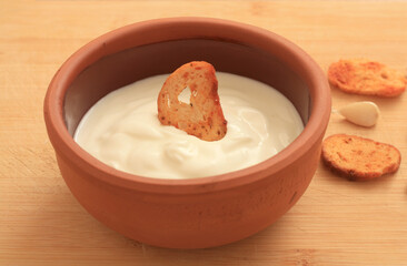 Sour cream in a wooden bowl. Farm organic product