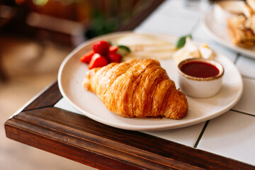 Golden croissant with strawberry marmalade and berries