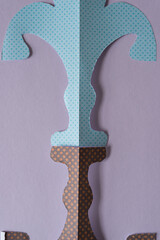 end parts of paper fleur-de-lis on violet paper