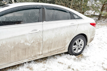 Dirty car automobile at home backyard outdoor at winter snowy day. Vehicle before cleaning at car wash garage station