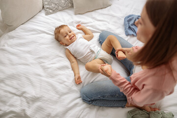 Young lady with her kid during changing the clothes