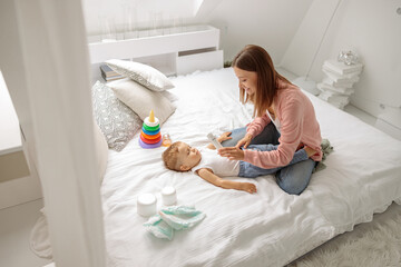 Mother with her baby boy during changing the clothes