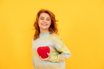 cheerful redhead woman with red heart on yellow background. love