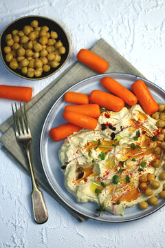 Hummus With Olive Oil And Baby Carrots On A Plate.