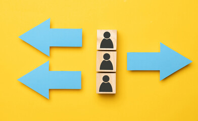 Wooden cubes with arrows in opposite directions on a yellow background. Concept of thinking...