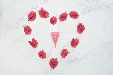 Reusable menstrual cup with bougainvillea flowers in the shape of a heart.