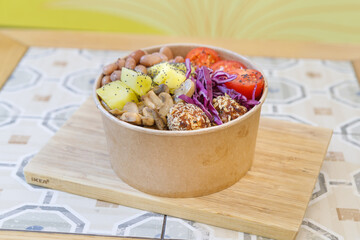 Vegeterian seafood bowl with smoked salmon, shrimp, avocado in take out paper container. Close up, copy space, top view, background.