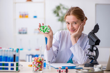 Young female chemist in drugs synthesis concept