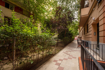Fototapeta na wymiar Entrance hall to urban housing building with gardens and trees