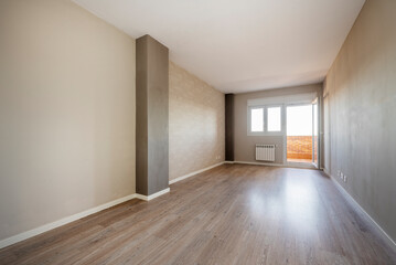 Fototapeta premium Empty living room with access to a terrace with brick walls and aluminum radiator next to it