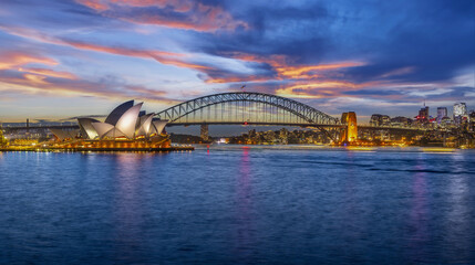 Naklejka premium Sydney Harbour Australia at Sunset with the turquoise colours of the bay and high rise offices of the City in the background