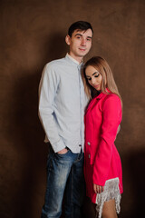 A girl in a beautiful pink dress hugs a man in a shirt and trousers