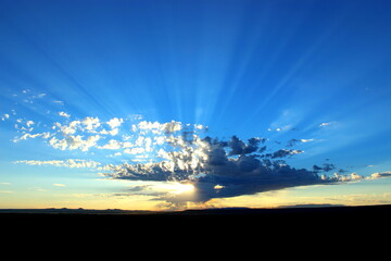 Sun rays through a cloud at sunrise