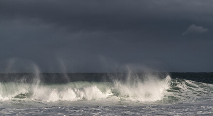 Obraz premium Seascape. Powerful ocean wave on the surface of the ocean. Wave breaks on a shallow bank. Stormy weather, stormy clouds sky background.