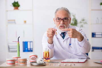 Old male doctor dentist working in the clinic