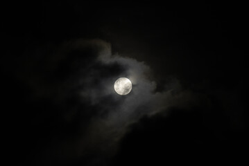 Full Moon Behind Clouds on Black Sky. Dramatic Sky. Horror Sky. Serenity Nature Background.
