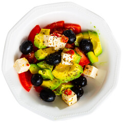 Appetizing vegetable salad made from sweet red pepper, tomatoes, avocado, olives, cheese and seasoned with olive oil. Isolated over white background