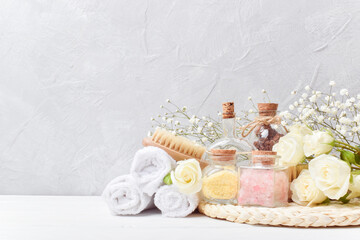 Spa treatments and massages. Various cosmetics for cosmetic procedures. Various bath bottles and white roses.