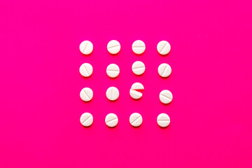 White round pills in a row on vivid pink background with copy space.