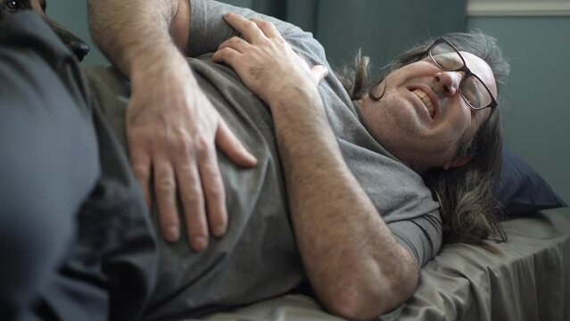 Man With Intense Stomach Ache Laying in Bed and Suffering