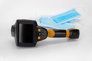 thermal imager and medical masks on a white background. temperature control. body temperature measuring device and virus protection.