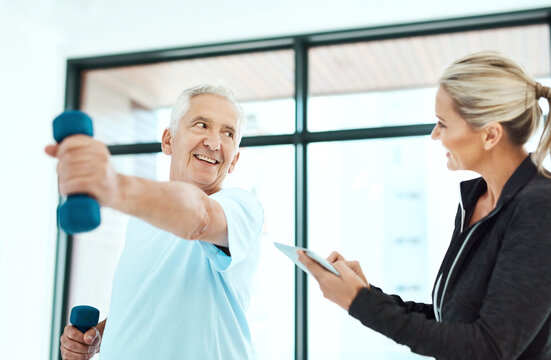 You're are doing better each day. Shot of a physiotherapists helping her senior patient with his exercises in a fitness center.
