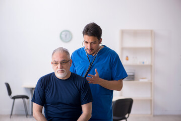 Fototapeta premium Old man visiting young male doctor