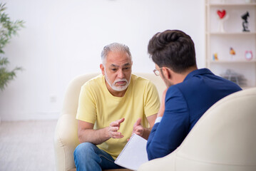 Old man visiting young male psychotherapist