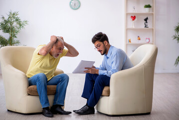 Old man visiting young male psychotherapist