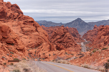 Overton, Nevada, USA - February 24, 2010: Valley of Fire. Gray asphalt road meanders down between 2...