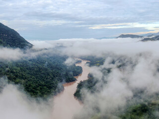river floating through amazon at sunrise with clouds over trees in tarapoto