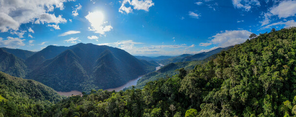 Aerial panorama of amazon rainforest in Tarapoto/Peru with blue sky and river flowing through pristine and untouched landscape - obrazy, fototapety, plakaty