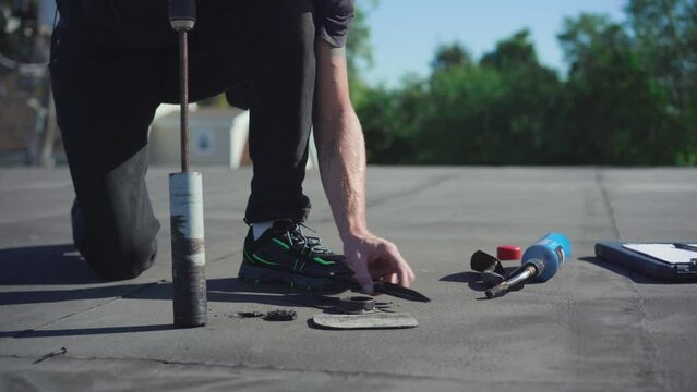 Roofing Inspector performing a core test on a flat roof on a sunny day