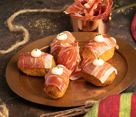 Side view of delicious iberian ham croquettes with kimchi mayonnaise. Traditional spanish recipe.