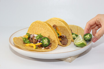 Beef tacos with green jalapeño, red onion, cilantro and yellow chili on integral tortilla with hot sauce