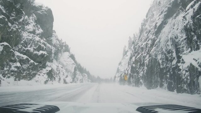 driving snow covered road in the mountains