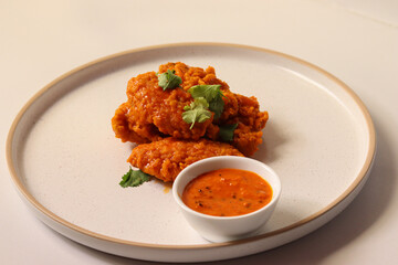 spicy buffalo wing on a plate served gourmet decorated with coriander leaves