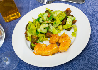 Appetizing juicy chicken breast with vegetable salad made from lettuce leaves, cucumbers, tomatoes and avocado